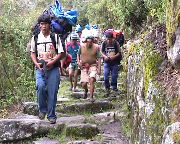people with backpacks walking the last part of the Inca trail into Machu Pichu