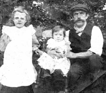 Photo from c1906 showing grandmother as a baby in highchair with her father and eldest half sister