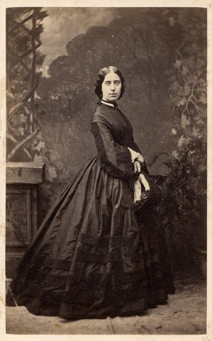 Lady dressed in dark crinoline dress of mid 19th century
