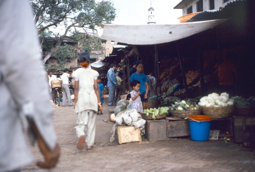 Market vegetable stall with woman and child