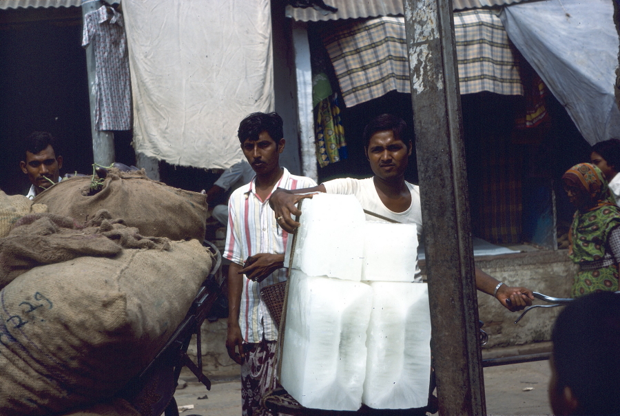 Two young men delivering large blocks of ice