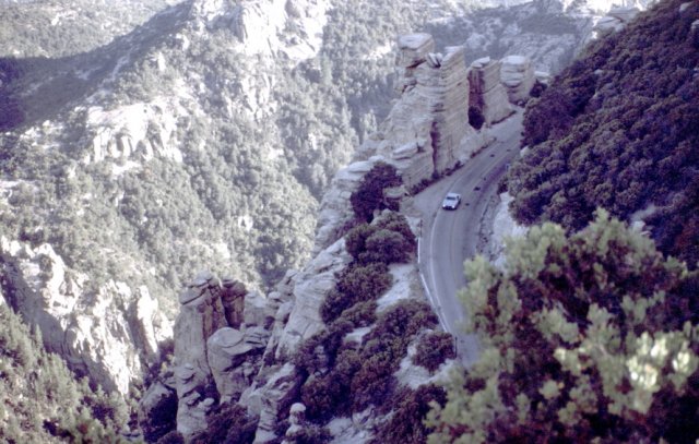 View down into valley with road twisting its way up the mountain side